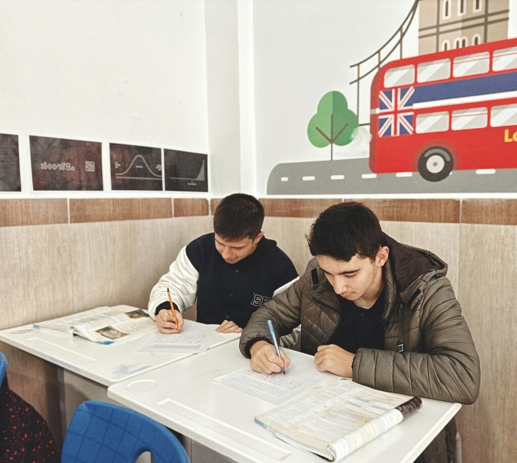 Two students focused on study materials in a London-themed classroom setting.